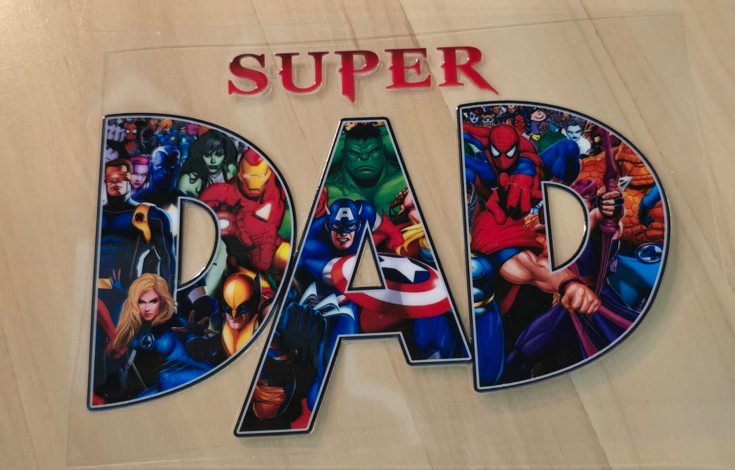 Colorful superhero-themed sticker, Super Dad with superhero filling in the letters DAD