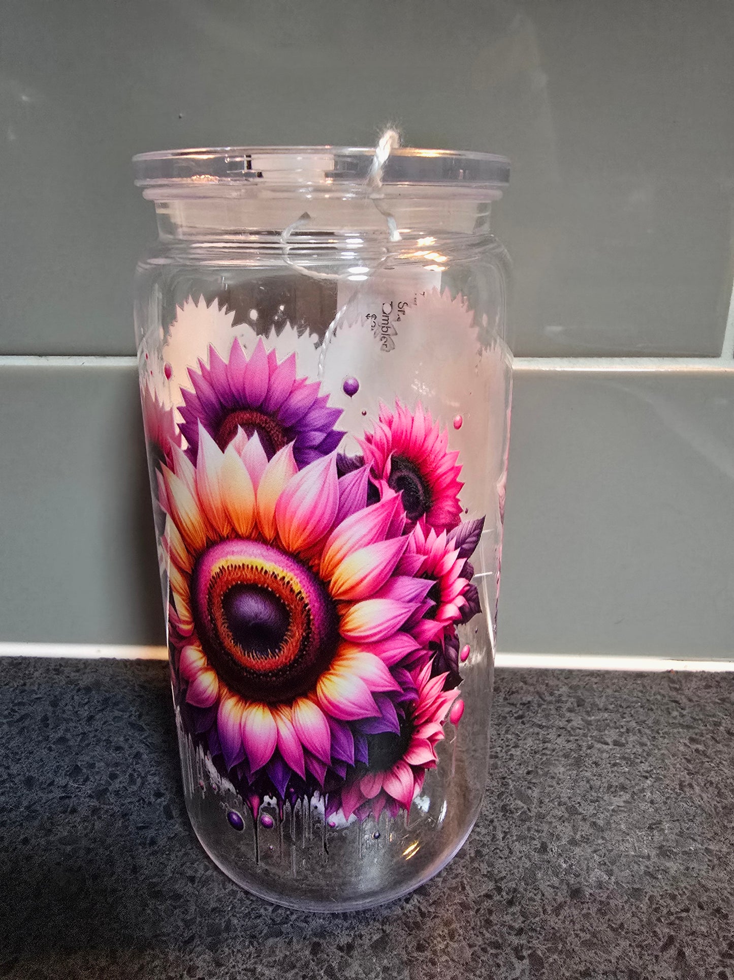 Clear tumbler with a colorful floral design on a gray background