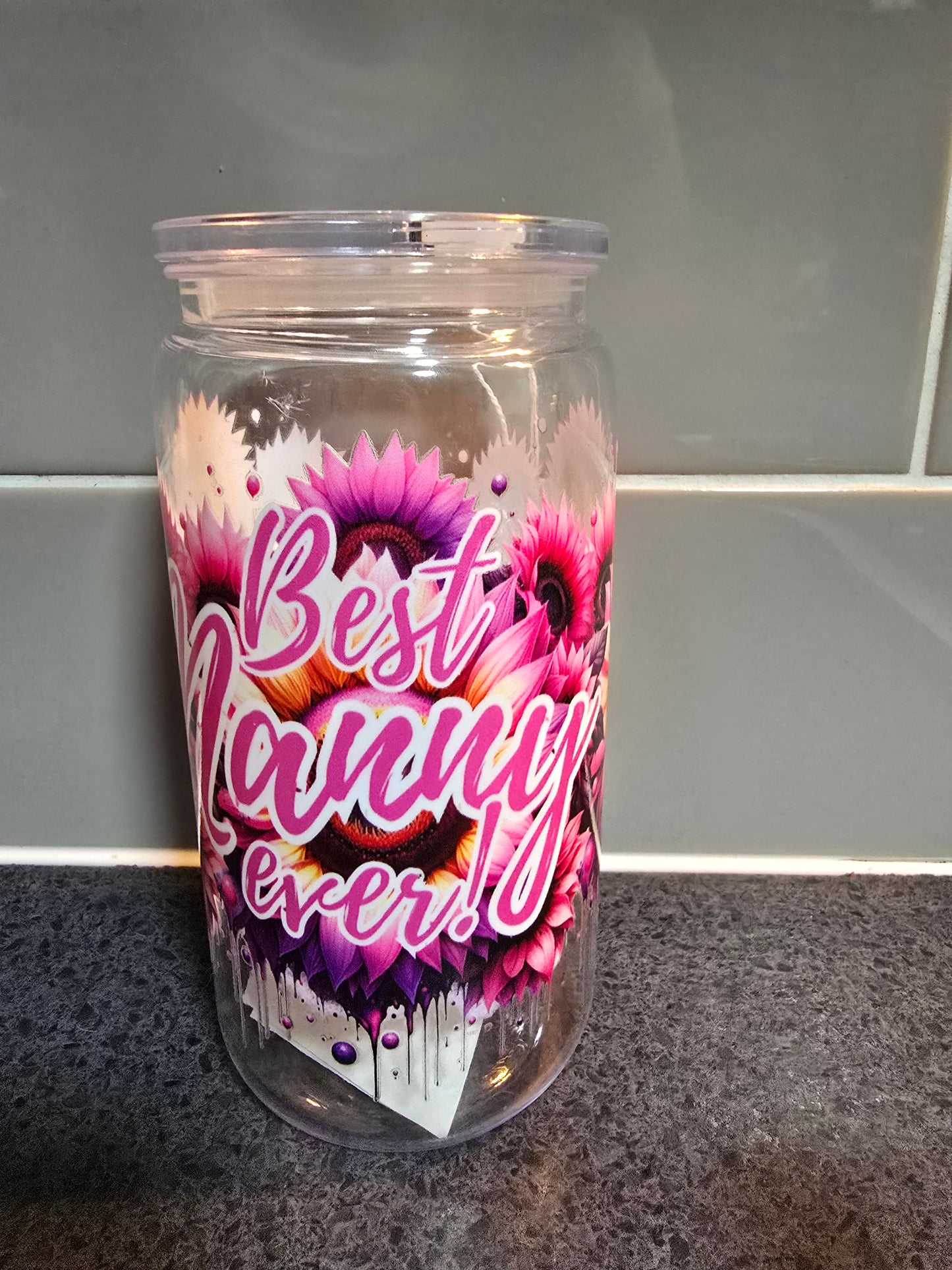 Tumbler with floral design and 'Best Nanny Ever' text on a tiled wall background